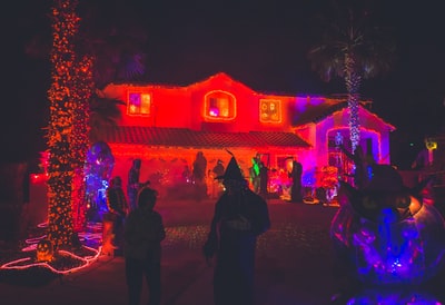 夜间，人们站在装饰有红灯的房子附近